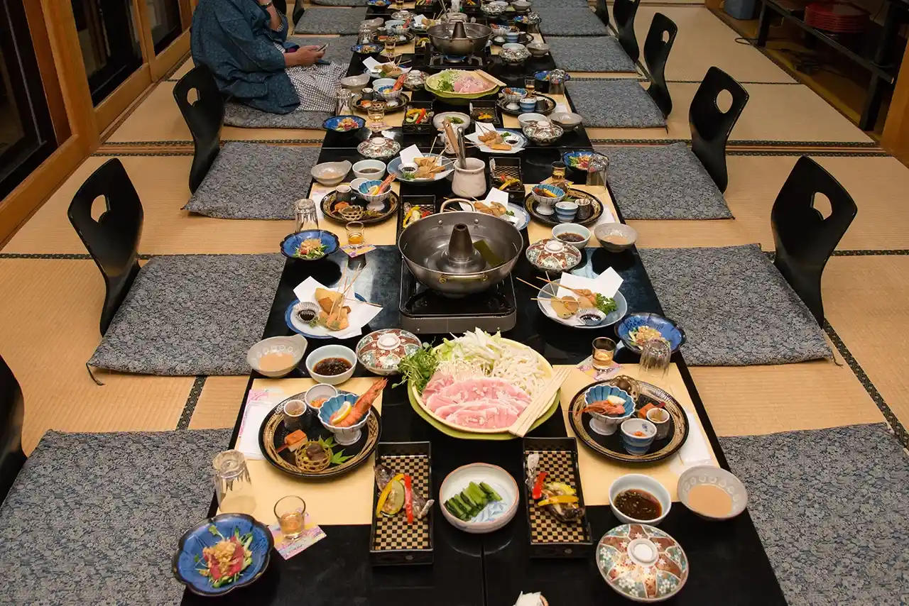 温泉旅館の畳の間での食事が並んでいる
