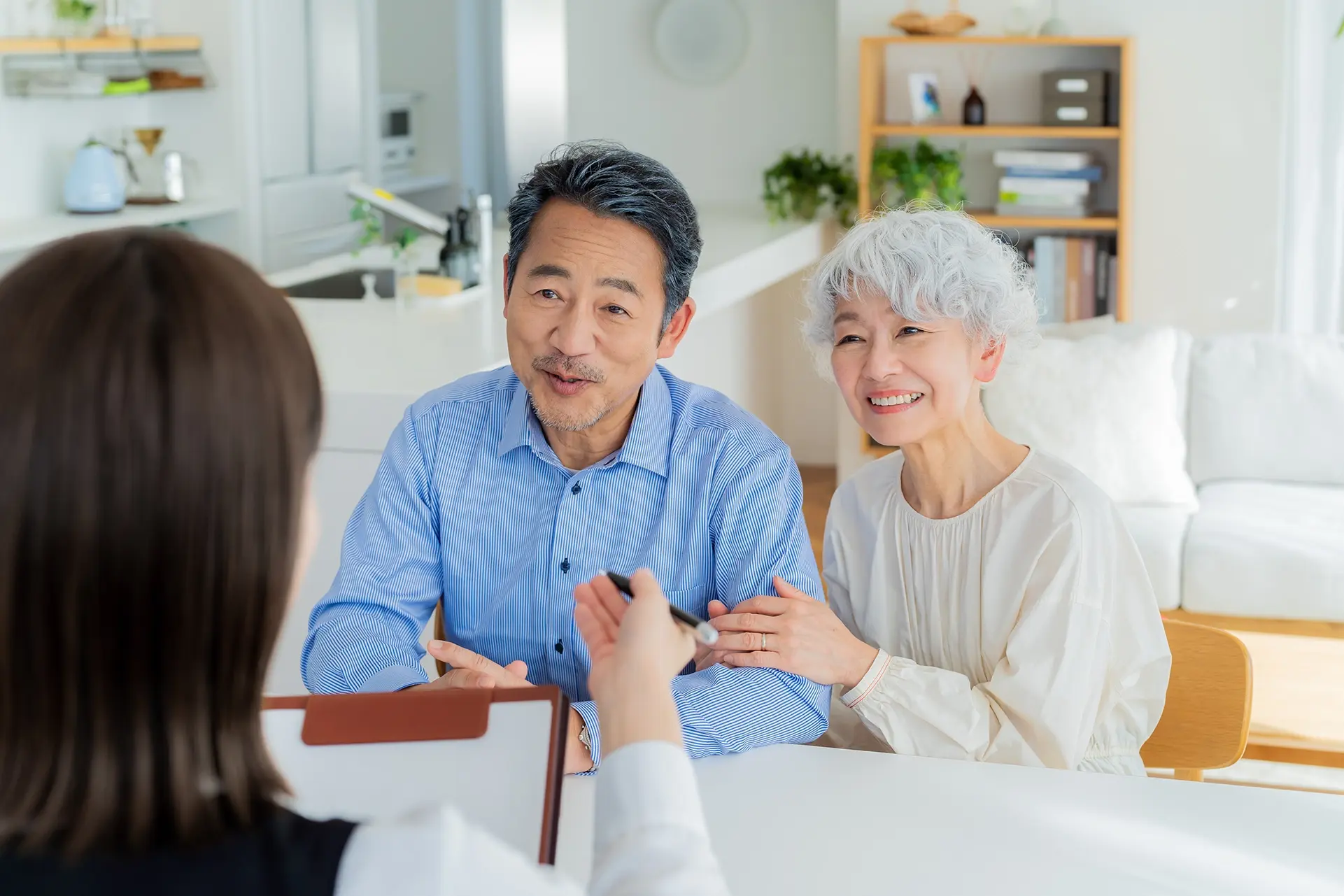 明るい部屋で担当者の説明を笑顔で聞くシニア夫婦